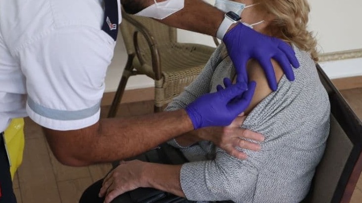 Magen David Adom medic administers COVID-19 vaccine to elderly woman at nursing home in central Israel (Photo: Moti Kimchi) אישה מתחסנת בבית אבות משען