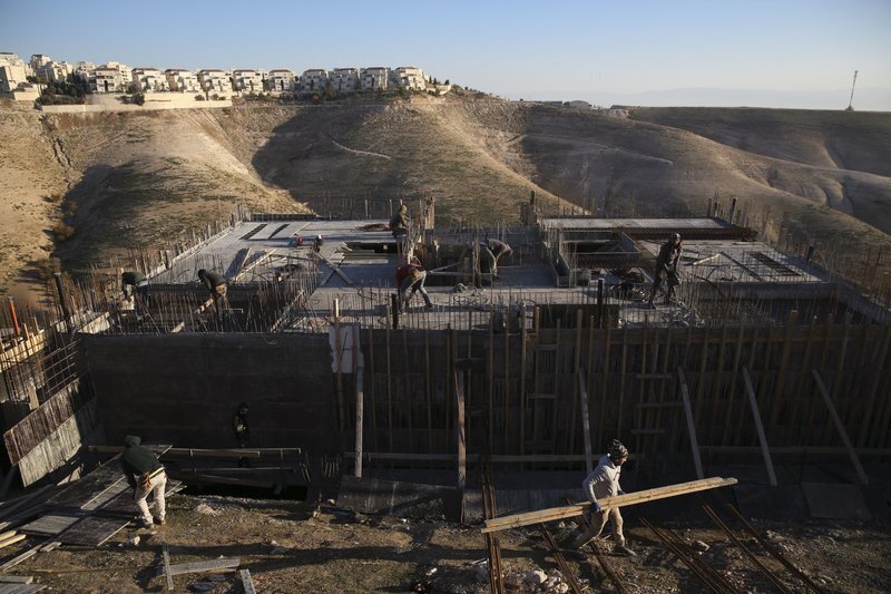 Palestinian laborers work at a construction site in the Israeli settlement of Maale Adumim, near Jerusalem 