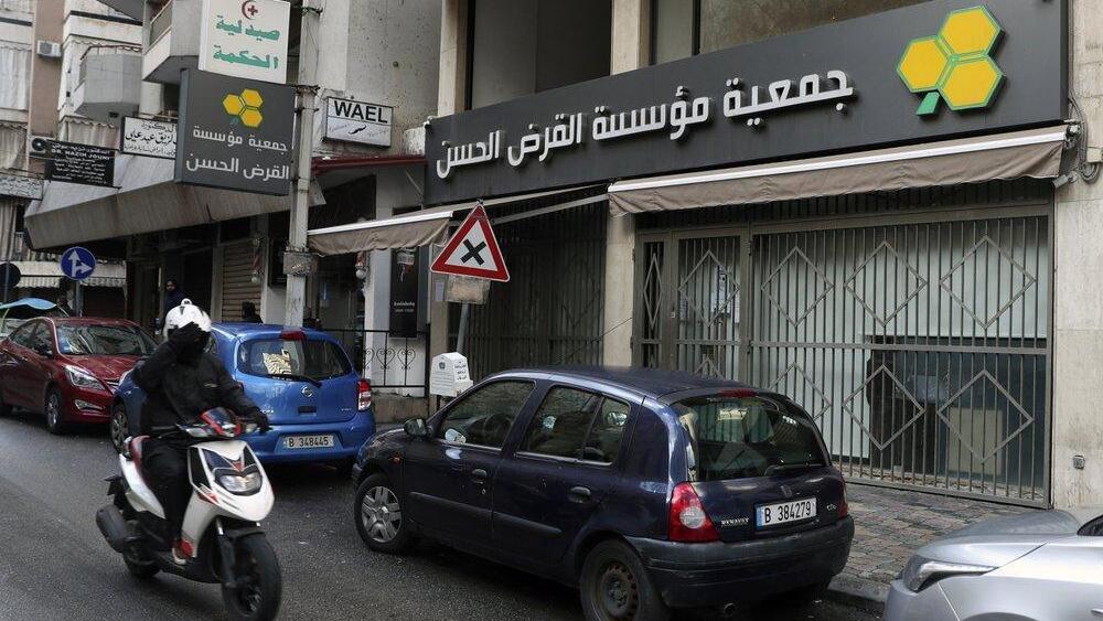 A man on a scooter passes a branch of the Hezbollah-run Qard al-Hassan Association, in Beirut, Lebanon (Photo: AP) A man on a scooter passes a branch of the Hezbollah-run Qard al-Hassan Association, in Beirut, Lebanon