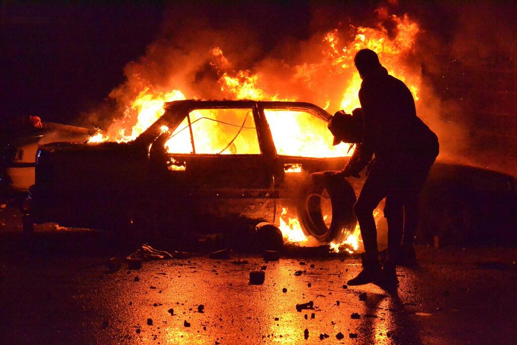 רכב עולה באש במהומות בטריפולי (צילום: AFP) לבנון מהומות קורונה טריפולי