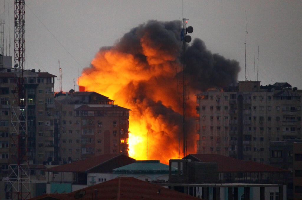 Illustrative: An IDF airstrike in Gaza (Photo: AFP/Archive) In this file photo taken on August 23, 2014 a ball of fire rises from a building following an Israeli air strike in Gaza City