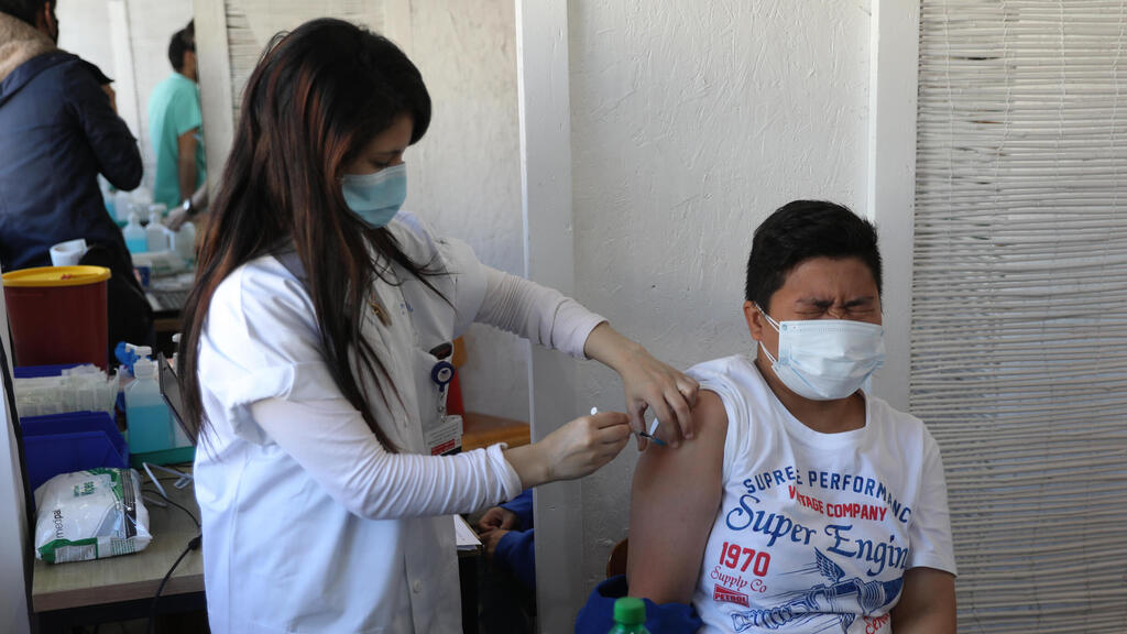 A foreign national receives the COVID-19 vaccine at the new vaccination center in Tel Aviv 