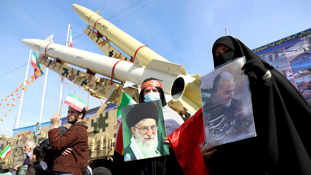 Iranian women hold pictures of the Supreme Leader Ayatollah Ali Khamenei and the late Iranian Major-General Qassem Soleimani, during the celebration of the 42nd anniversary of the Islamic Revolution in Tehran