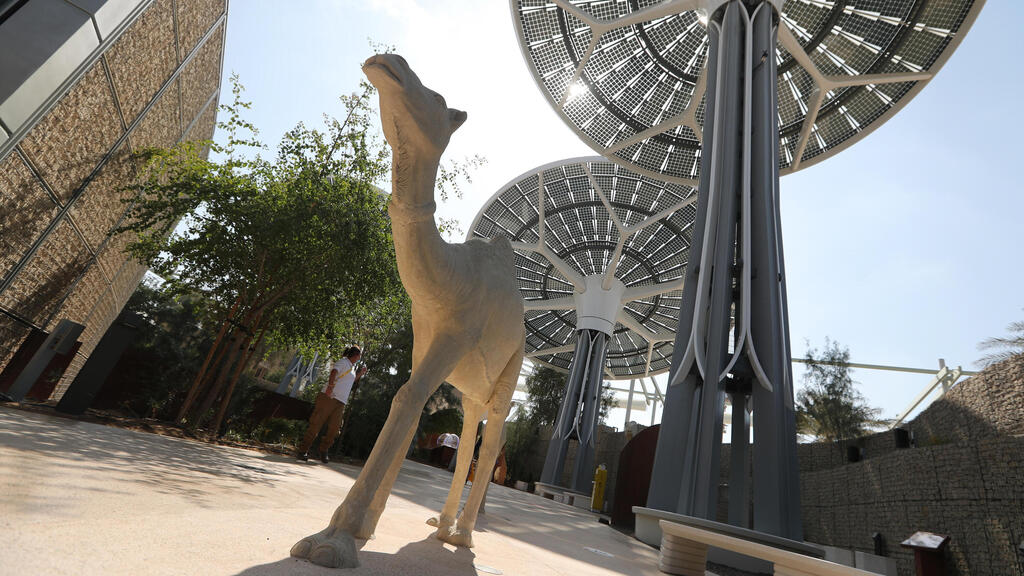 People walk at the building of Terra the Sustainability Pavilion at Expo 2020 Dubai site 
