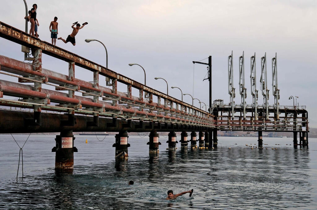 Youths jump into the Red Sea water off an abandoned oil jetty in Eilat, Feb. 2021 (Photo: AFP) Youths jump into the Red Sea water off an abandoned oil jetty in Eilat, Feb. 2021