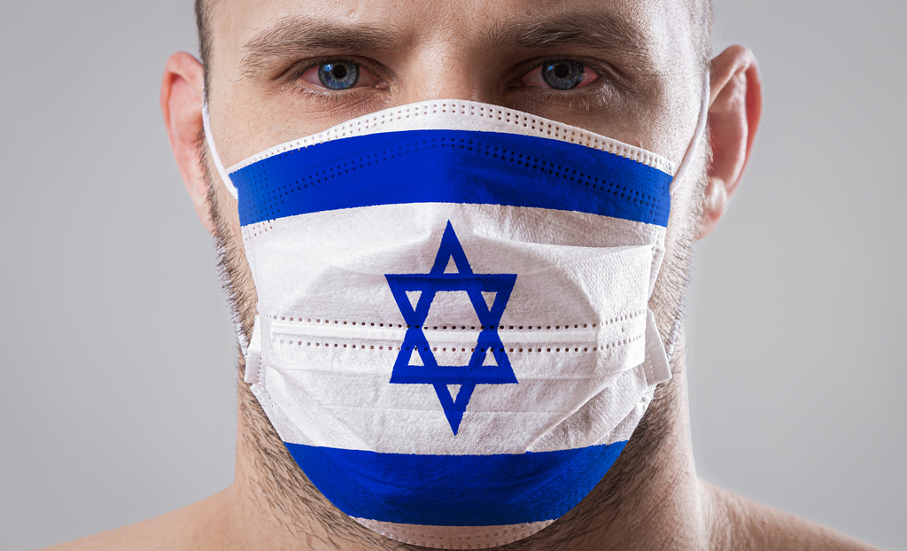 A man wear a face mask bearing the Israeli flag (Photo: Shutterstock) מסכה עם דגל ישראל