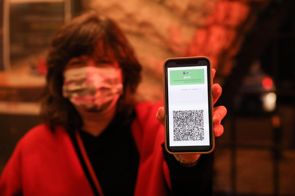 Woman displays her green pass through a cellphone app (Photo: EPA) התו הירוק
