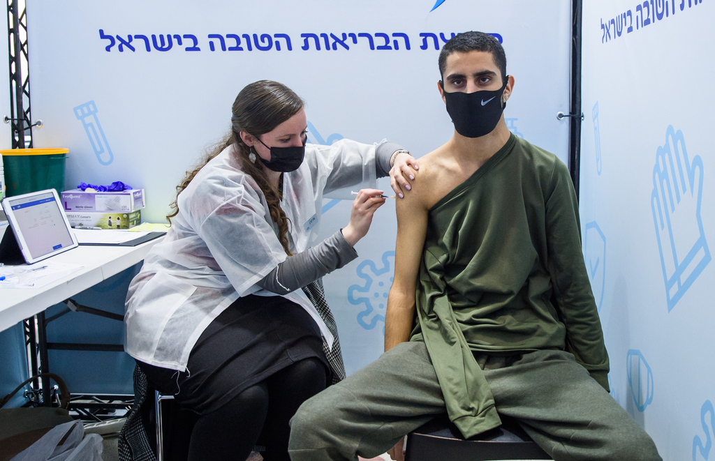 Health worker administers COVID-19 vaccine to 16-year-old teen in Jerusalem (Photo: Shalev Shalom) בן 16 מתחסן בירושלים