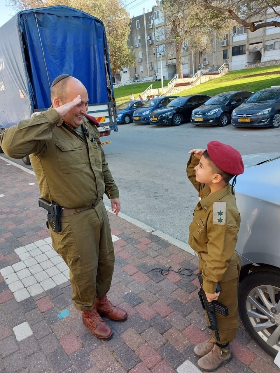 רס"ן אלי מלכה, שהאריך את שירותו הצבאי על מנת לשרת ביחידת אלה הנלחמת בהתפשטות הקורונה, והבן שלו, יהונתן - בן 7 וחצי - שבחר להתחפש לאביו, אותו הוא מעריץ (צילום: דובר צה"ל) רס"ן אלי מלכה ובנו יהונתן בן ה7
