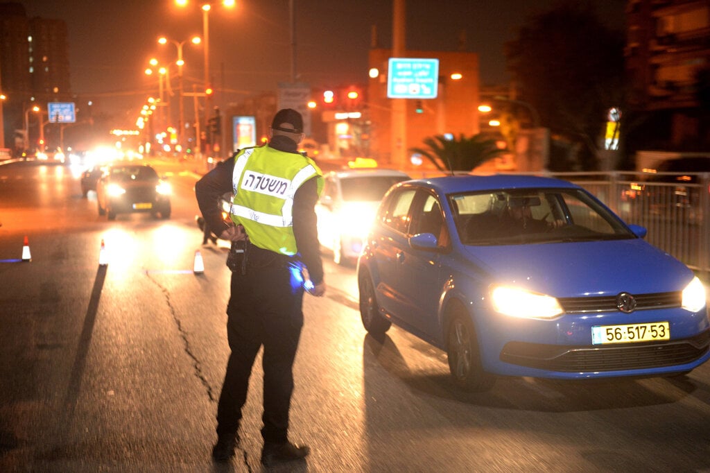 Police officer inspects passing vehicles at a checkpoint in Bat Yam during lockdown, February 25, 2021 (Photo: Kobi Koanks) מחסומים בת ים