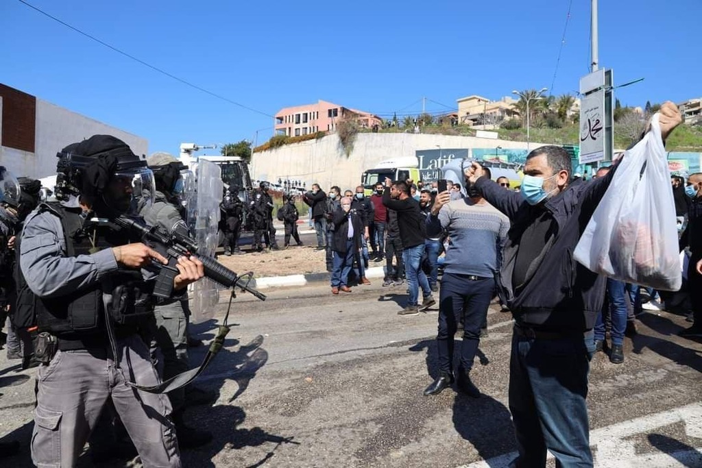 שוטרים מכוונים נשק למפגינים בהפגנה נגד האלימות באום אל פחם
