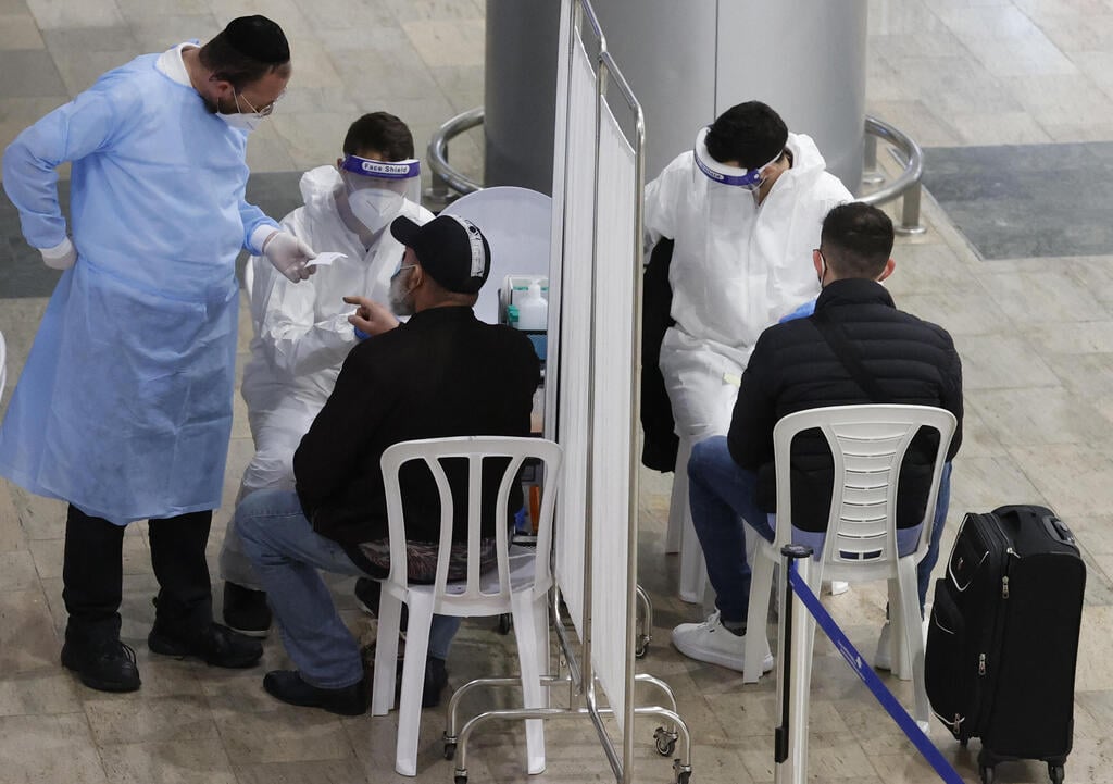 Health workers conducting coronavirus testing at Ben-Gurion Airport (Photo: AFP) בדיקות קורונה בנתב"ג