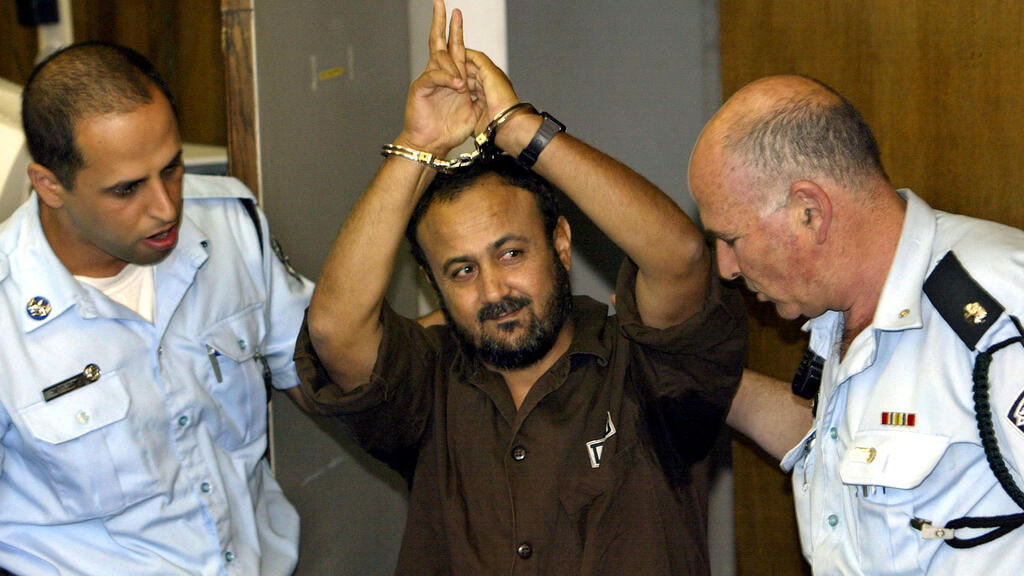 Marwan Barghouti, a popular Palestinian leader, gestures as Israeli police bring him into the District Court for his judgment hearing in Tel Aviv May 20, 2004/