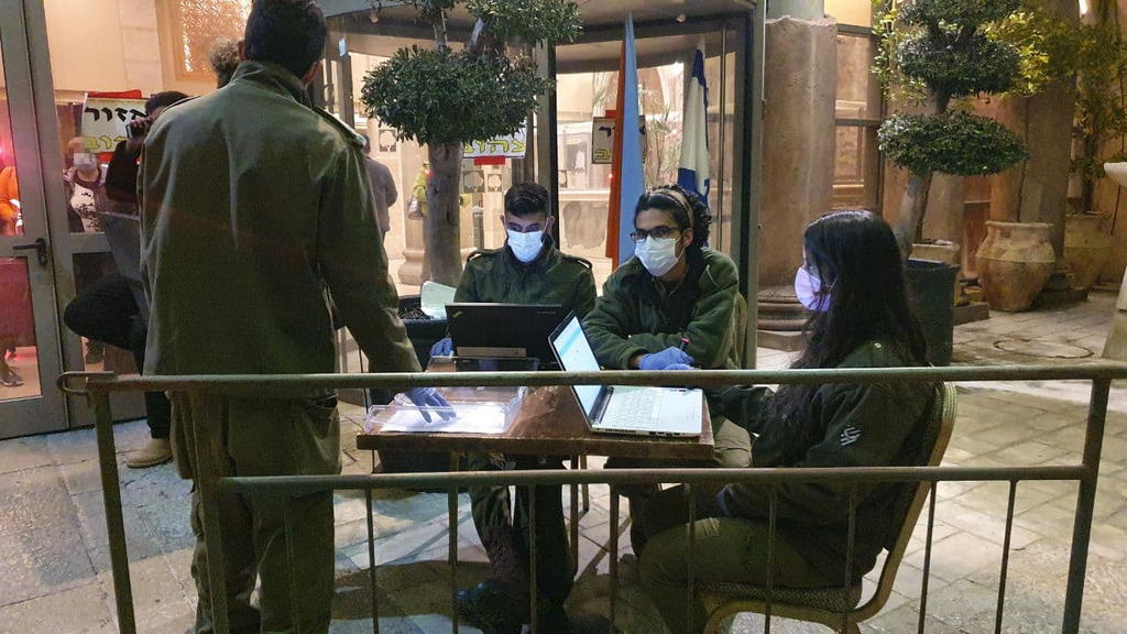 החיילים בכניסה למלון עץ הזית (צילום: אלי מנדלבאום) החל מחצות, השוהים במלונית קורונה יכולים לצאת לבידוד ביתי