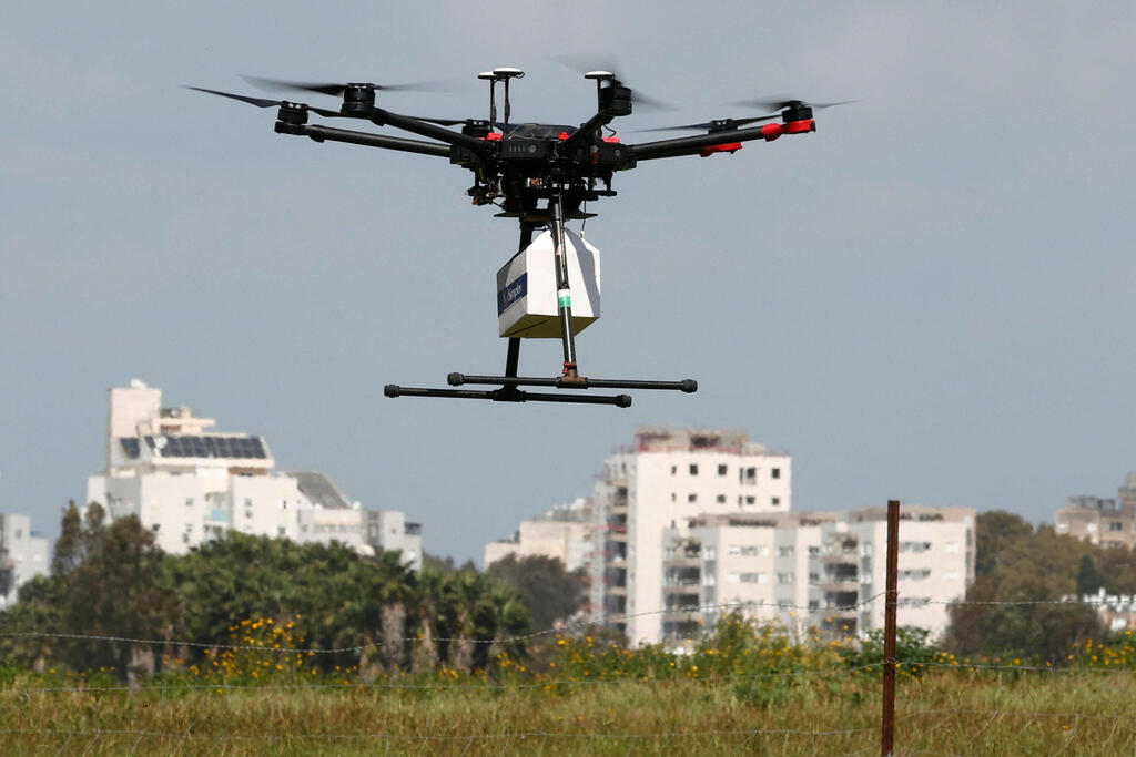 This picture taken on March 17, 2021 in the Israeli coastal city of Hadera shows an unmanned aerial vehicle (UAV, or drone) carrying e-commerce products as part of the main demonstration performed by the companies who won the tender for this project 