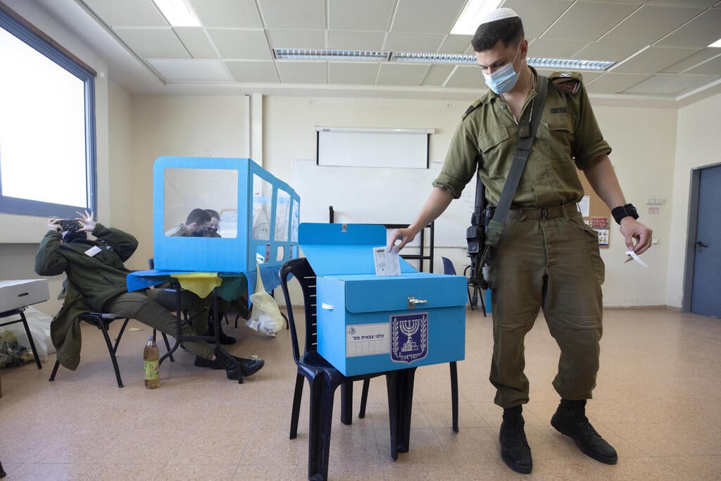 An IDF soldier casting an early ballot ahead of the March 23 election (Photo: AP) בחירות 2021 קלפי קלפיות צה"ל מצביעים הצבעה