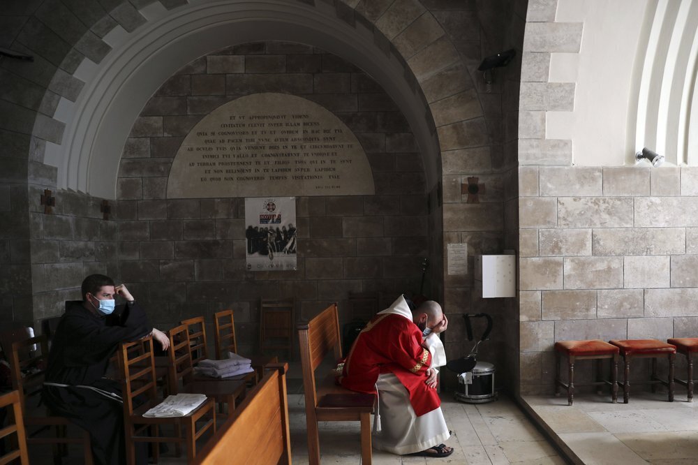 Priests pause on Palm Sunday on the Mount of Olives in Jerusalem 