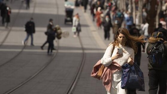 a woman carries shopping bags after coronavirus restrictions were eased, opening shopping centers, gyms, barber shops, among other sites in Jerusalem 