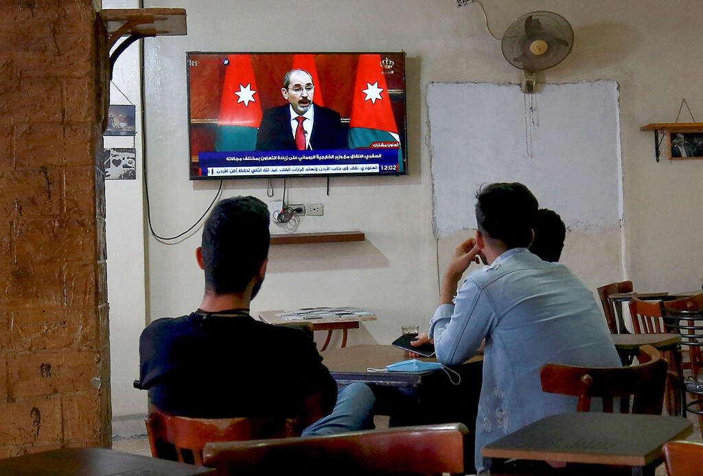 Men watching Jordan's Deputy Prime Minister Ayman Safadi address the nation after an alleged coup attempt in capital of Amman 