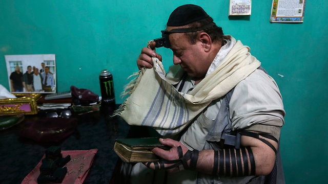 Zabulon Simantov laying tefillin at the synagogue in Kabul 