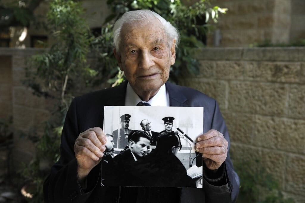 Retired Chief Justice Gabriel Bach holding a picture take of him during the Eichmann trial in 1960 (Photo: AFP) Retired Chief Justice Gabriel Bach holding his picture during the Eichmann trial in 1960