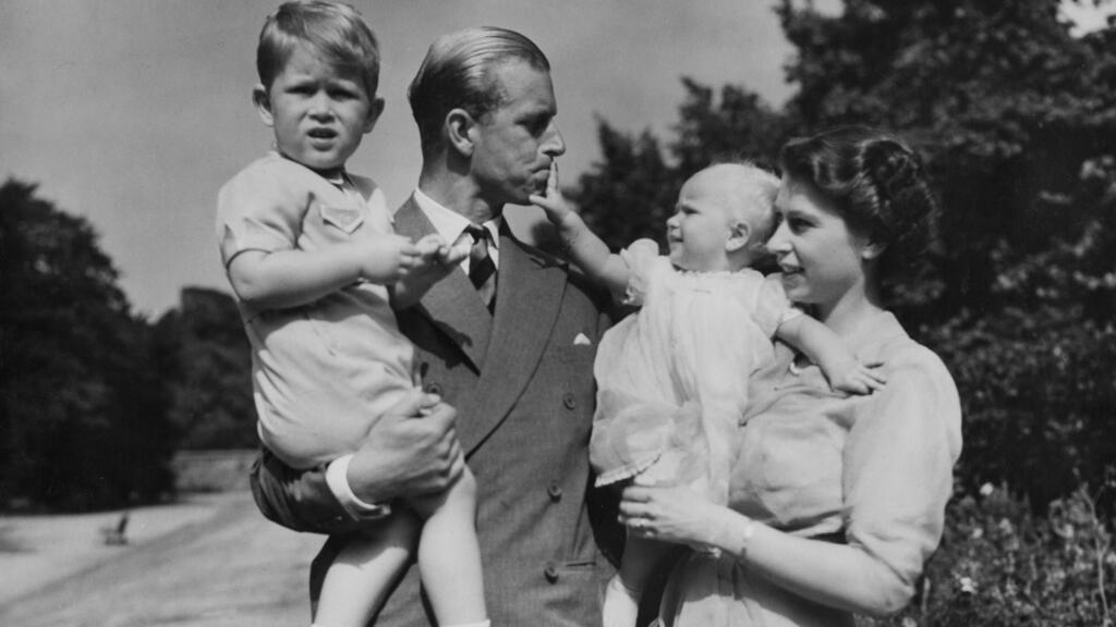 Then-Princess Elizabeth stands with her husband Prince Philip and their children Prince Charles and Princess Anne at Clarence House, August 1951 