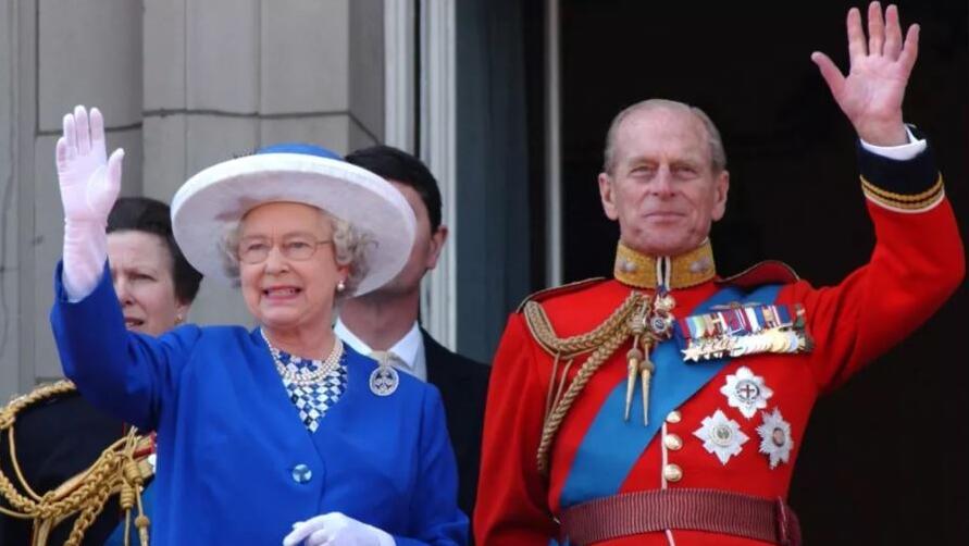 Queen Elizabeth II and Prince Philip wave from the balcony of Buckingham Palace during a flypast for the trooping of the colour, June 2003 