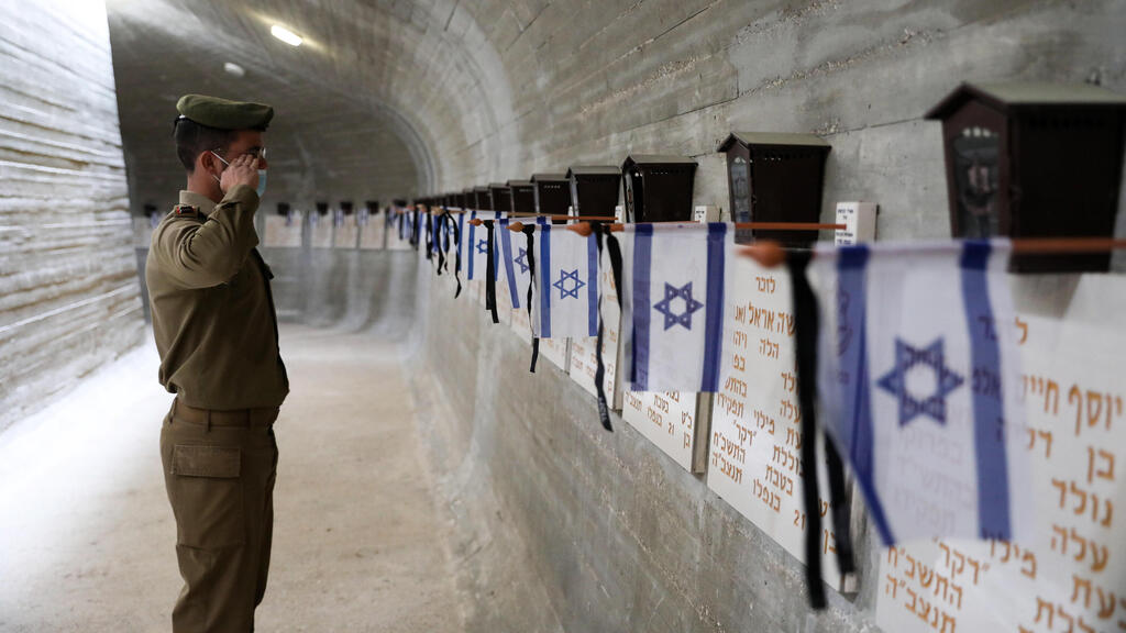 חייל מצדיע אל מול קברי חללי צה"ל