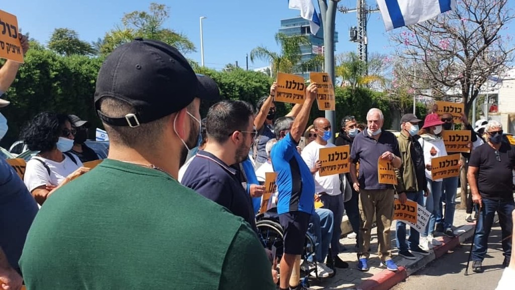 עשרות מפגינים במקום שבו הצית עצמו איציק סעידיאן (צילום: מושיק ברין) הלומי קרב ובני משפחותיהם מפגינים מול אגף השיקום