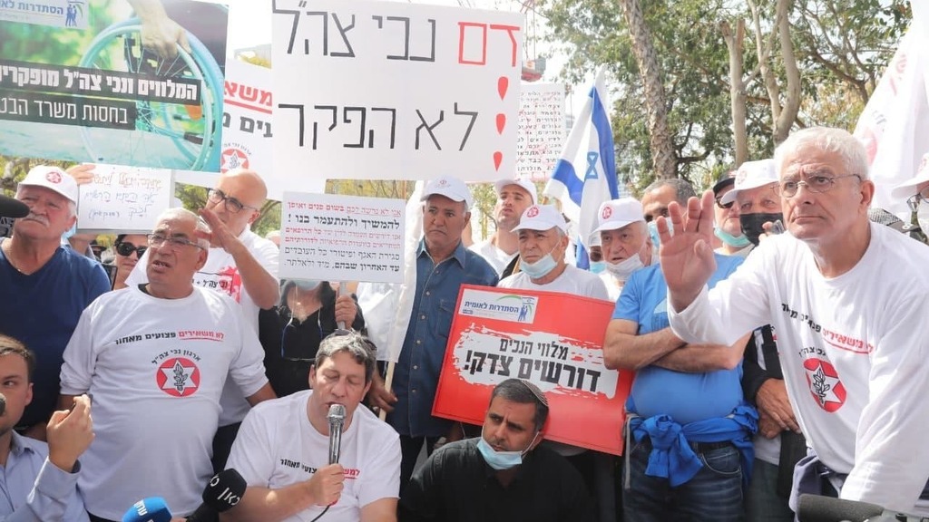 המחאות לאחר מעשה ההצתה (צילום: מוטי קמחי) יו"ר ארגון נכי צה"ל עו"ד עידן קלימן בהפגנת נכי צה"ל מול הקריה