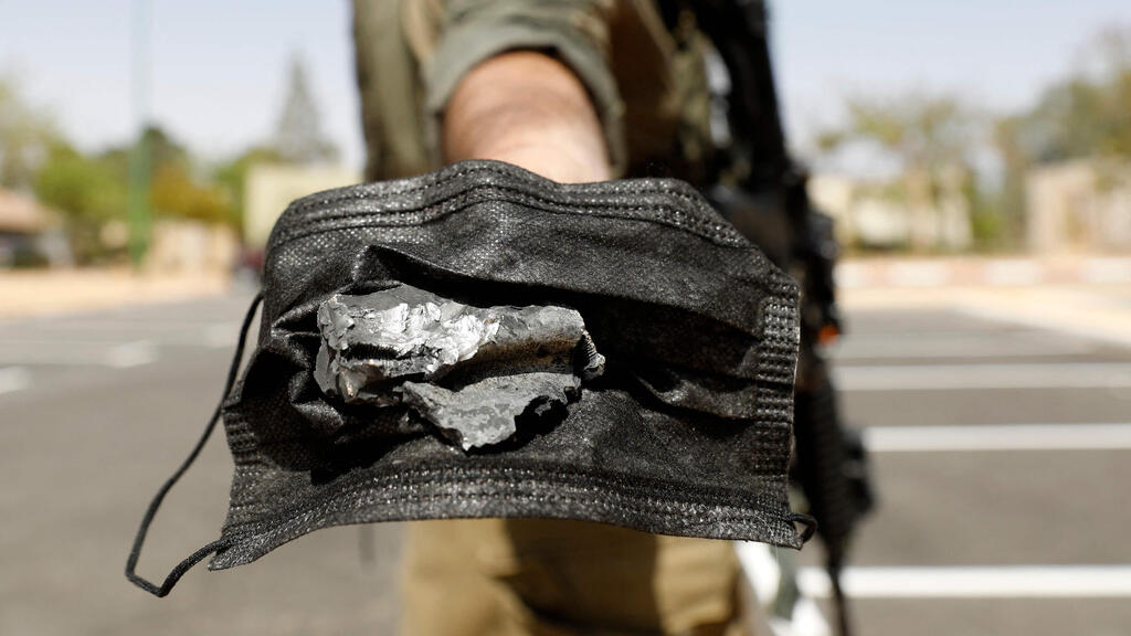 Soldier holds shrapnel from the Syrian missile (Photo: AFP) כוחות ביטחון בנגב