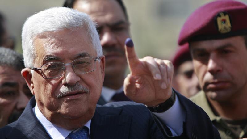 Palestinian President Mahmoud Abbas shows his ink-stained finger after casting his vote during local elections, at a polling station in the West Bank city of Ramallah 