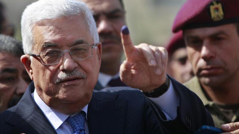 Palestinian President Mahmoud Abbas shows his ink-stained finger after casting his vote during local elections, at a polling station in the West Bank city of Ramallah 