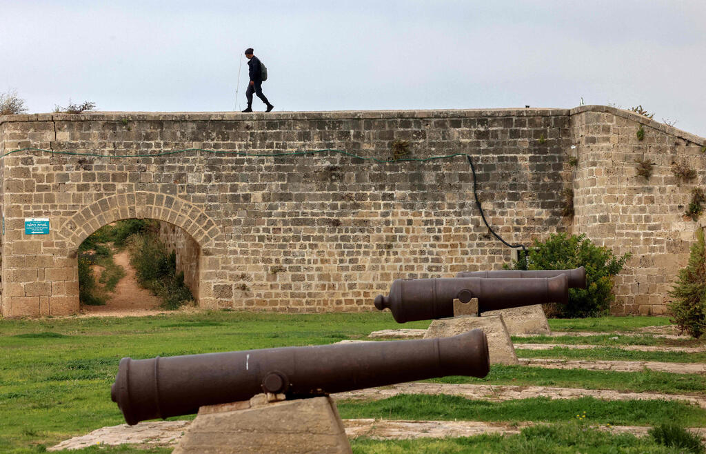 A man walks along the city walls of the old town Acre where  Napoleon Bonaparte and approximately 13,000 French soldiers started an unsuccessful siege of the Ottoman-controlled city on March 20, 1799
