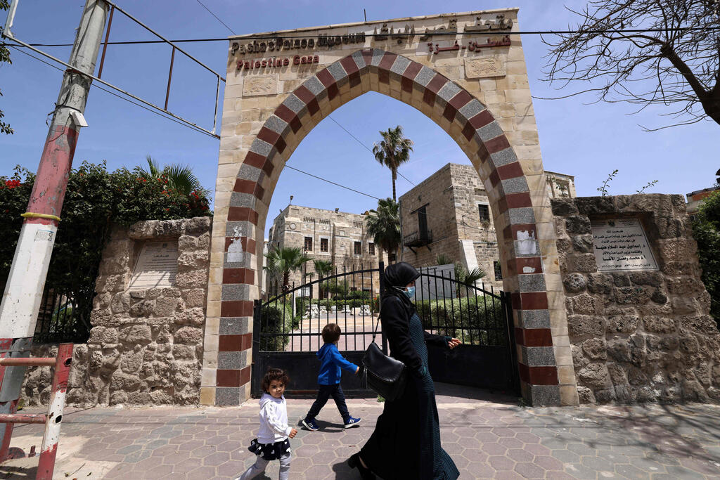 A woman and a child walk past Qasr al-Basha in Gaza City 