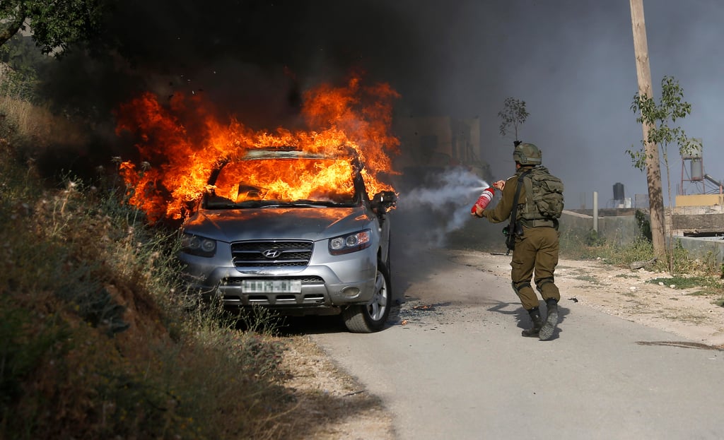 הרכב החשוד שהוצת בכפר עקרבא, אתמול (צילום: EPA) הרכב החשוד שהוצת