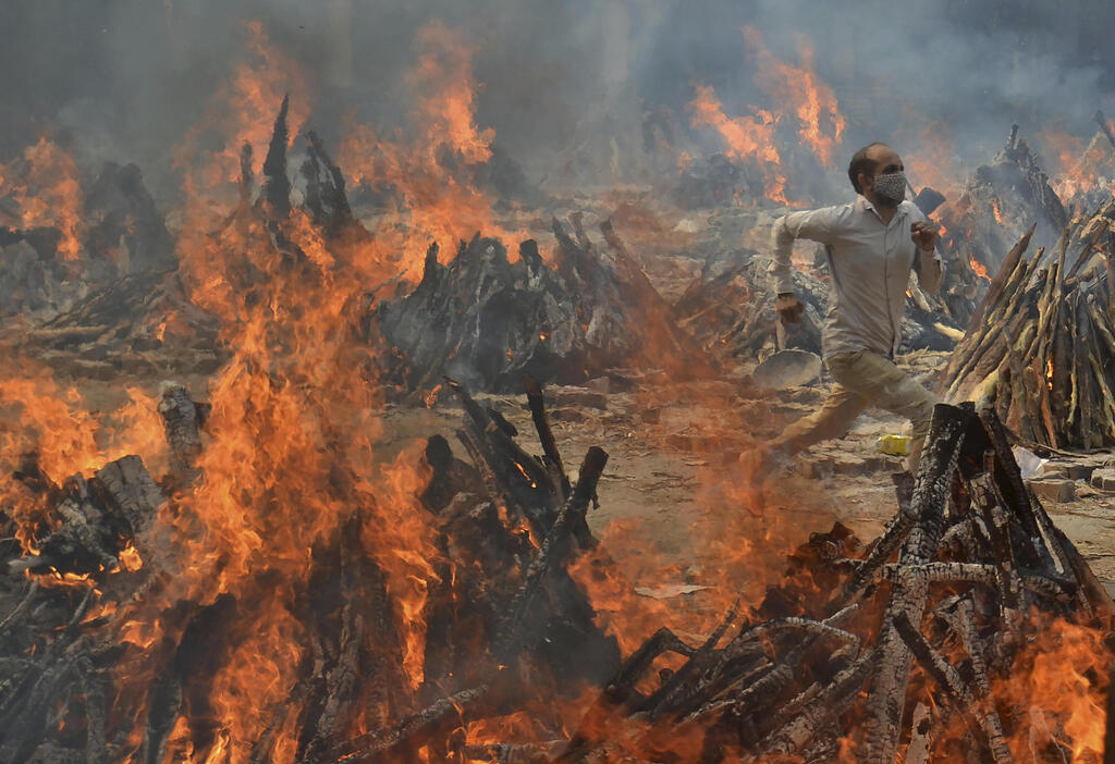 שריפת גופותיהם של חולי קורונה שמתו בניו דלהי (צילום: AP) שריפה של גופות חולי קורונה שמתו ניו דלהי הודו