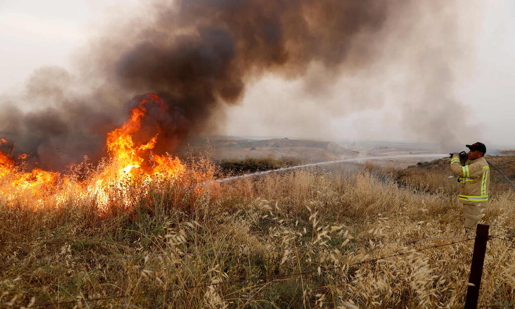 שריפה מבלון תבערה בעוטף עזה. ארכיון (צילום: AFP ) כיבוי שריפות ליד ניר עם