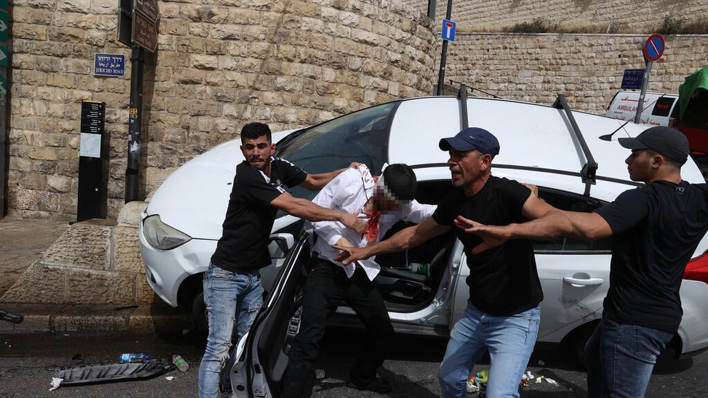 The Arab rioters attempting to pull out the driver from the car (Photo: Amit Shabi) The Arab rioters attempting to pull out the driver from the car