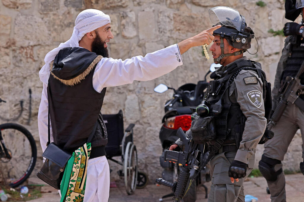 A Palestinian argues with a Border Police officer in the Old City of Jerusalem, May 10, 2021 (Photo: AFP) A Palestinian argues with a Border Police officer in the Old City of Jerusalem, May 10, 2021