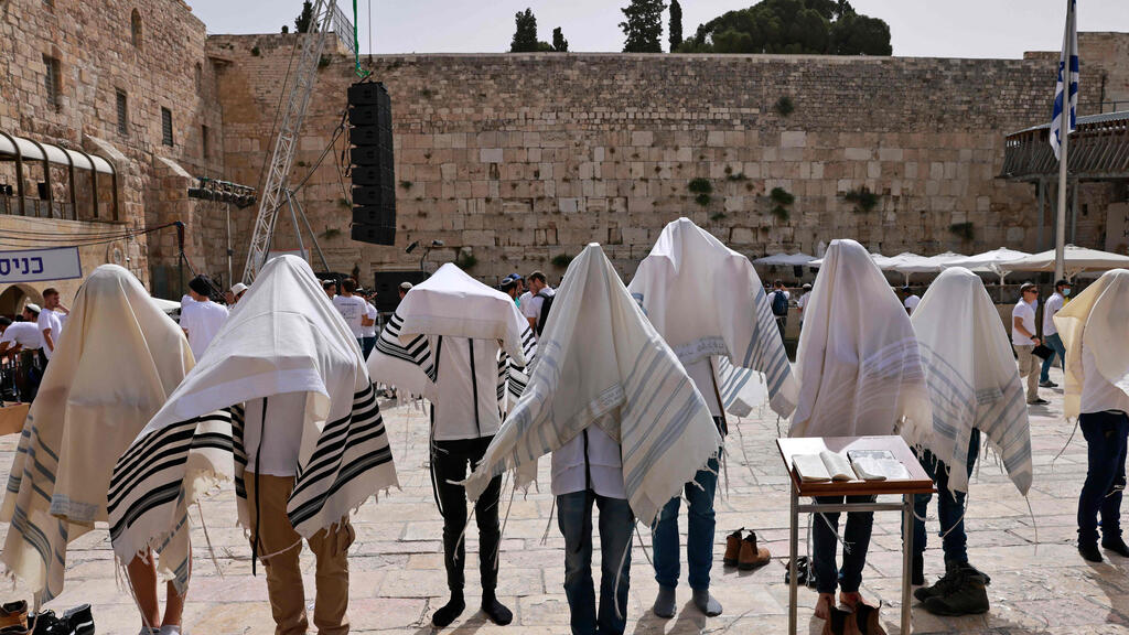 Jewish men pray near the Western Wall in the Old City of Jerusalem as Israel marks Jerusalem Day, May 10, 2021 