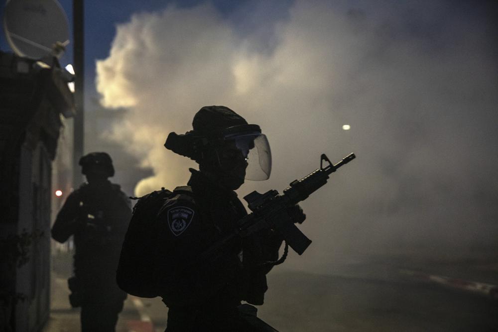 Israeli forces run during clashes with Israeli Arabs in the Israeli mixed city of Lod, Israel 