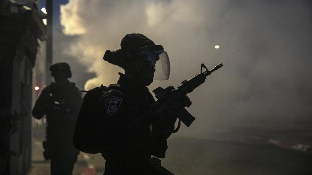 Israeli forces run during clashes with Israeli Arabs in the Israeli mixed city of Lod, Israel 