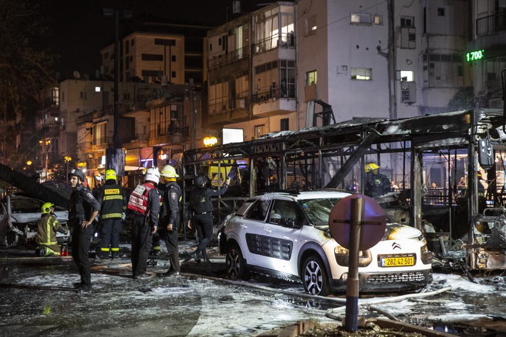 An Israeli firefighter works at the site where a rocket fired from the Gaza Strip, hit the central Israeli town of Holon, near Tel Aviv 