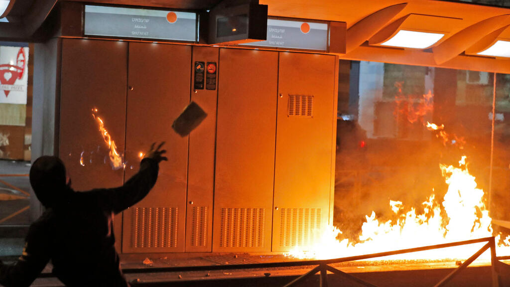 East Jerusalem rioters throws a firebomb during clashes on Friday (צילום: AFP) פלסטיני זורק בקבוק תבערה במזרח ירושלים