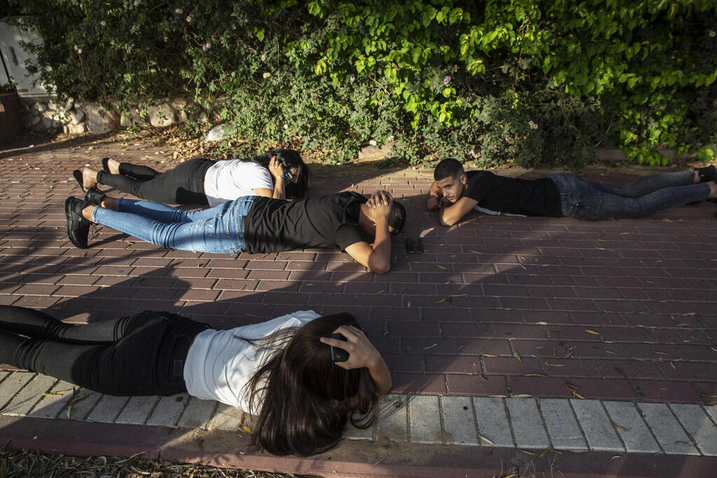 תופסים מחסה בזמן אזעקה באשקלון (צילום: AP) אנשים תופסים מחסה בזמן אזעקה