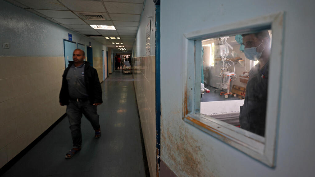 A Palestinian medic looks through a window in Shifa hospital in Gaza