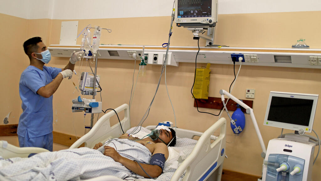 A wounded Palestinian man lies on a bed in Shifa hospital in Gaza