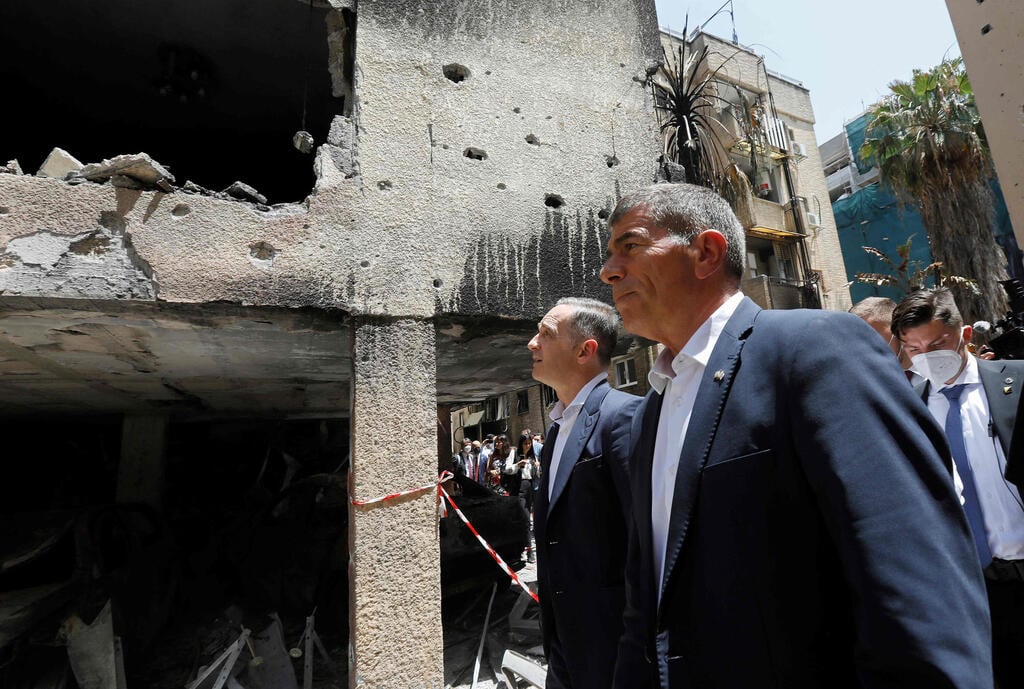 German Foreign Minister Heiko Maas and then-Israeli counterpart Gabi Ashkenazi visit a Petah Tikva home hit by a Gaza rocket during the most recent conflict with Palestinian terrorist factions, May 20, 2021 (Photo: AFP) גבי אשכנזי ושרי החוץ של גרמניה, צ'כיה וסלובקיה מבקרים בבניין בו פגעה רקטה