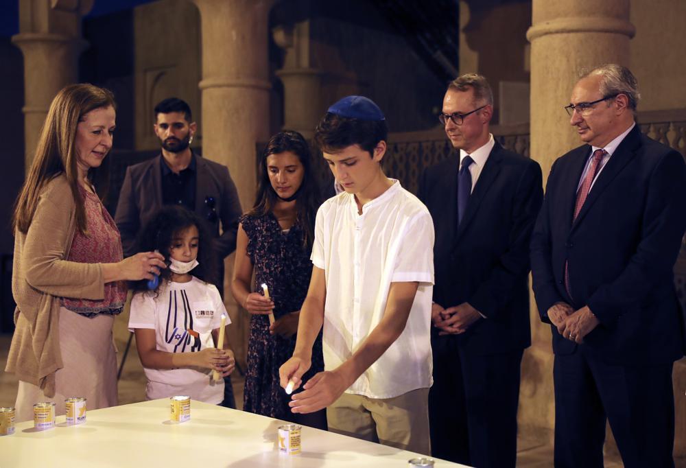 Israeli's Ambassador to the United Arab Emirates, Eitan Na'eh, right, and German Ambassador in UAE, Peter Fischer, second right, watch a candlelight ceremony at an exhibition commemorating the Jewish Holocaust in Dubai 